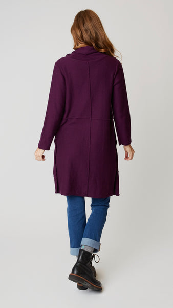 Model wearing cotton tunic-length sweater with high-low hemline, midwash boyfriend jeans, and black leather boots.