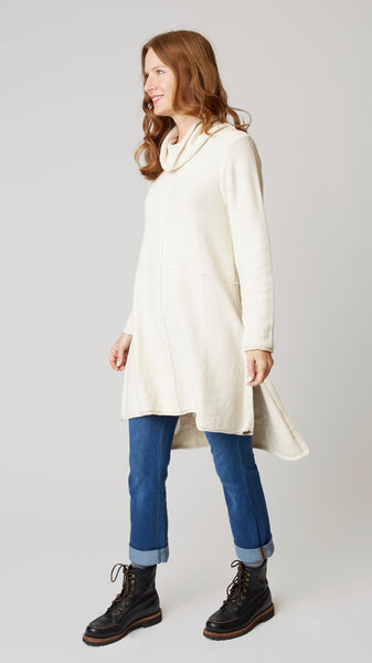 Model wearing cotton tunic-length sweater with high-low hemline, midwash boyfriend jeans, and black leather boots.