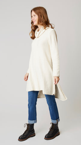 Model wearing cotton tunic-length sweater with high-low hemline, midwash boyfriend jeans, and black leather boots.