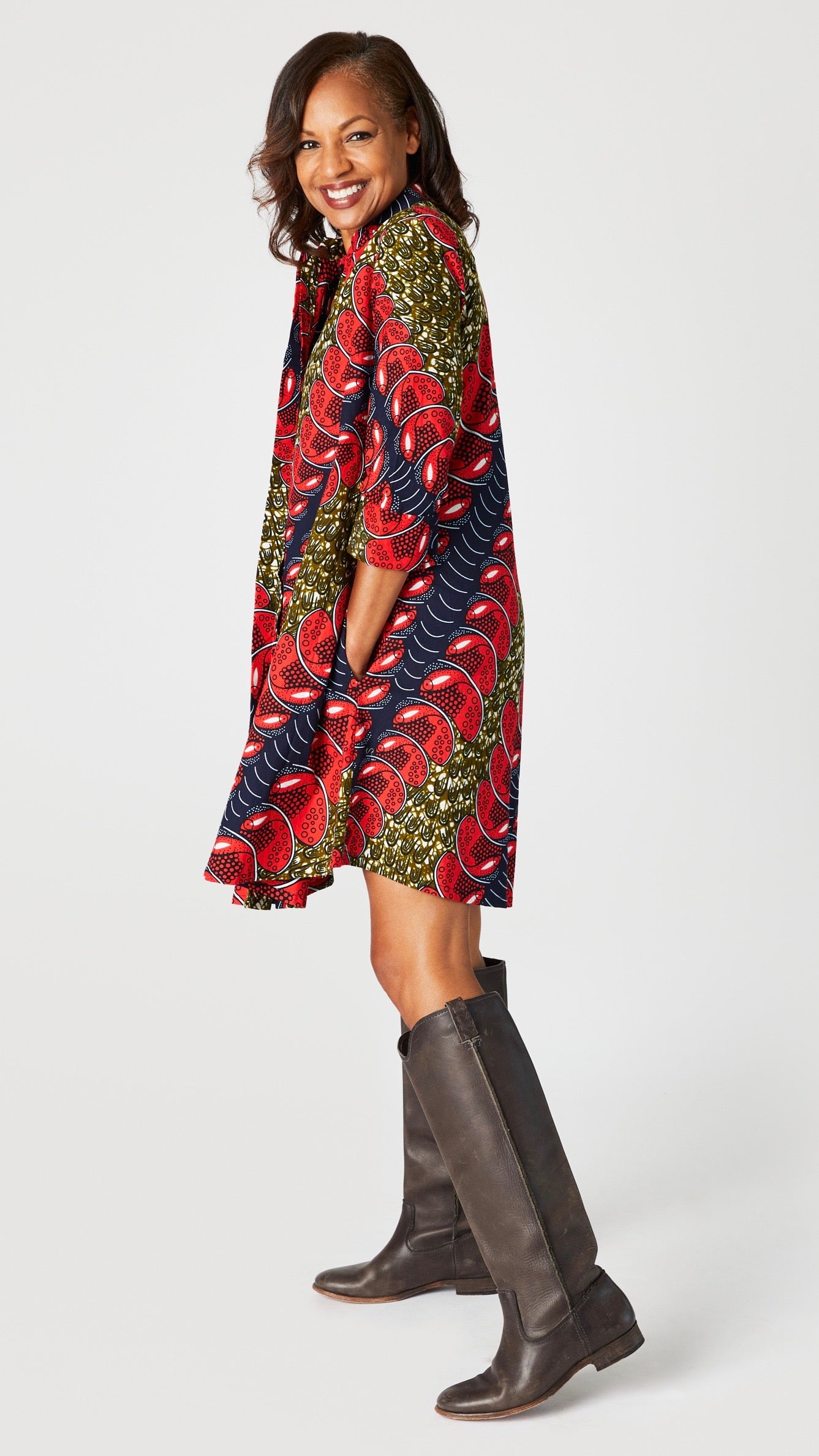 Model wearing "Red Herring" print Zuri dress with brown leather boots.