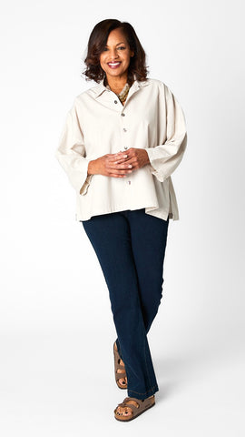 Model wearing cloud button-up top with relaxed hemline and 3/4 sleeves over indigo baby bootcut jeans and brown sandals.