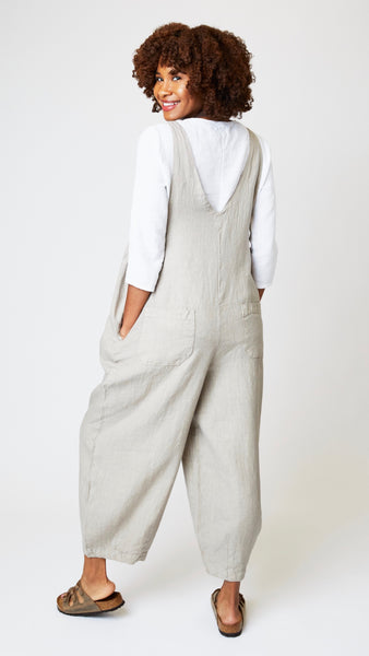 Model wearing rye linen overalls with cropped dart legs, white 3/4 sleeve top, and brown leather sandals.