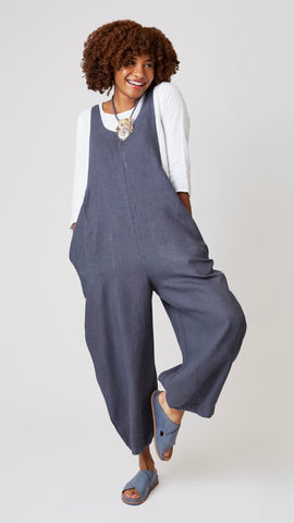 Model wearing gray linen overalls with cropped dart legs, white 3/4 sleeve top, and gray suede sandals.