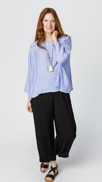 Model wearing black rayon cropped dart pant, lavender cropped rayon top with dropped shoulder and 3/4 sleeves, and black sandals.