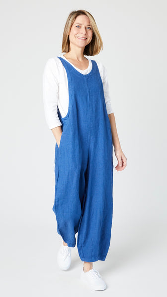 Model wearing white cotton-linen knit 3/4 sleeve bias cut tee, ocean california overalls white sneakers.